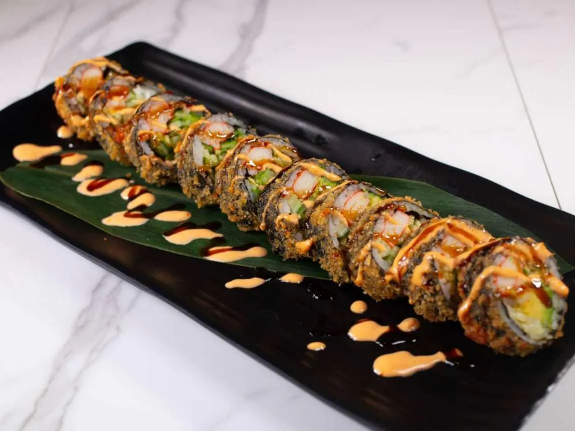 Crispy-coated sushi roll with shrimp & veggies, drizzled with sauces at Taki Sushi, a Japanese Restaurant in Toronto