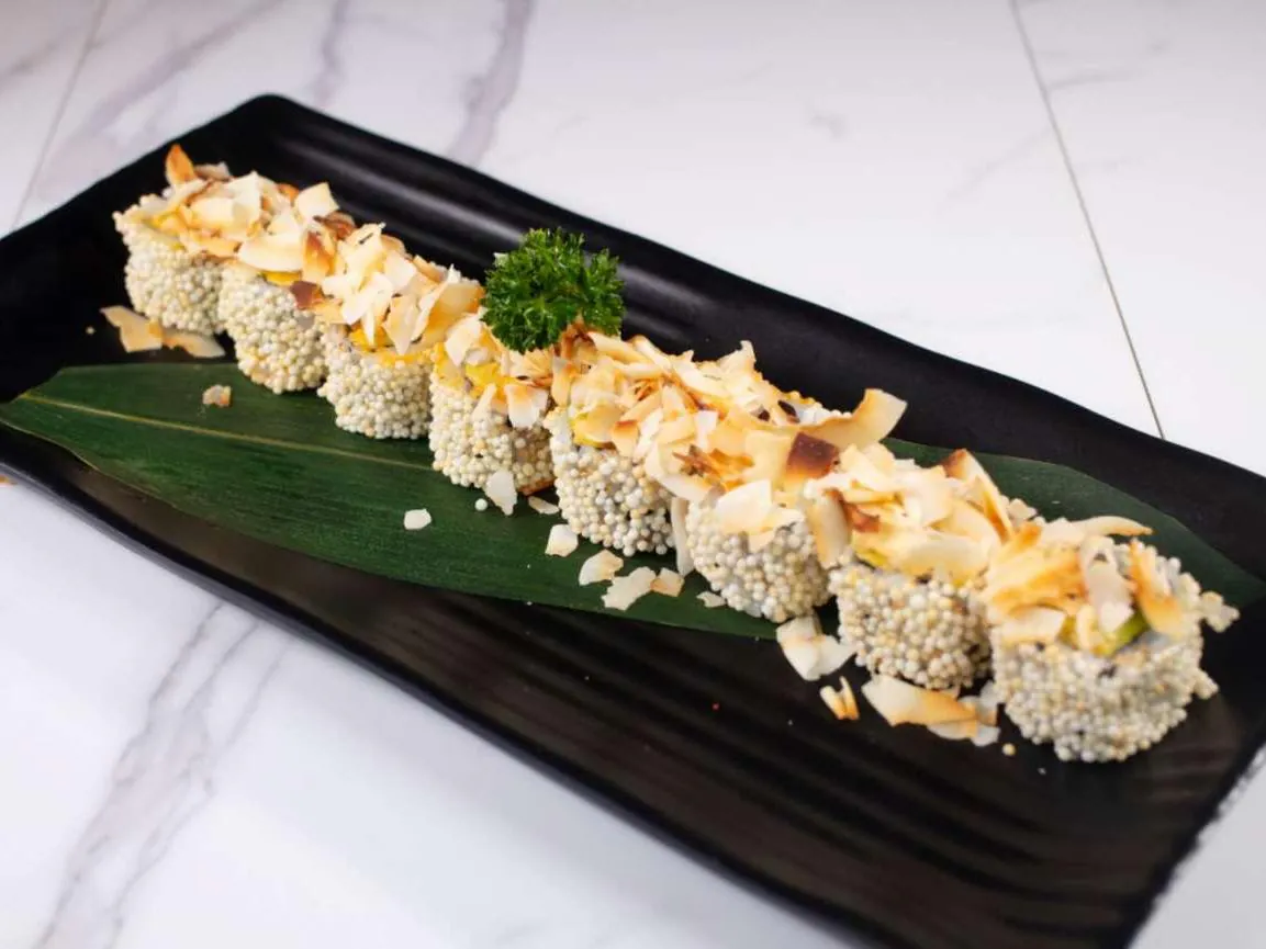 Sushi roll coated in white pearls, topped with toasted coconut flakes at Taki Sushi, a Japanese Restaurant in Toronto