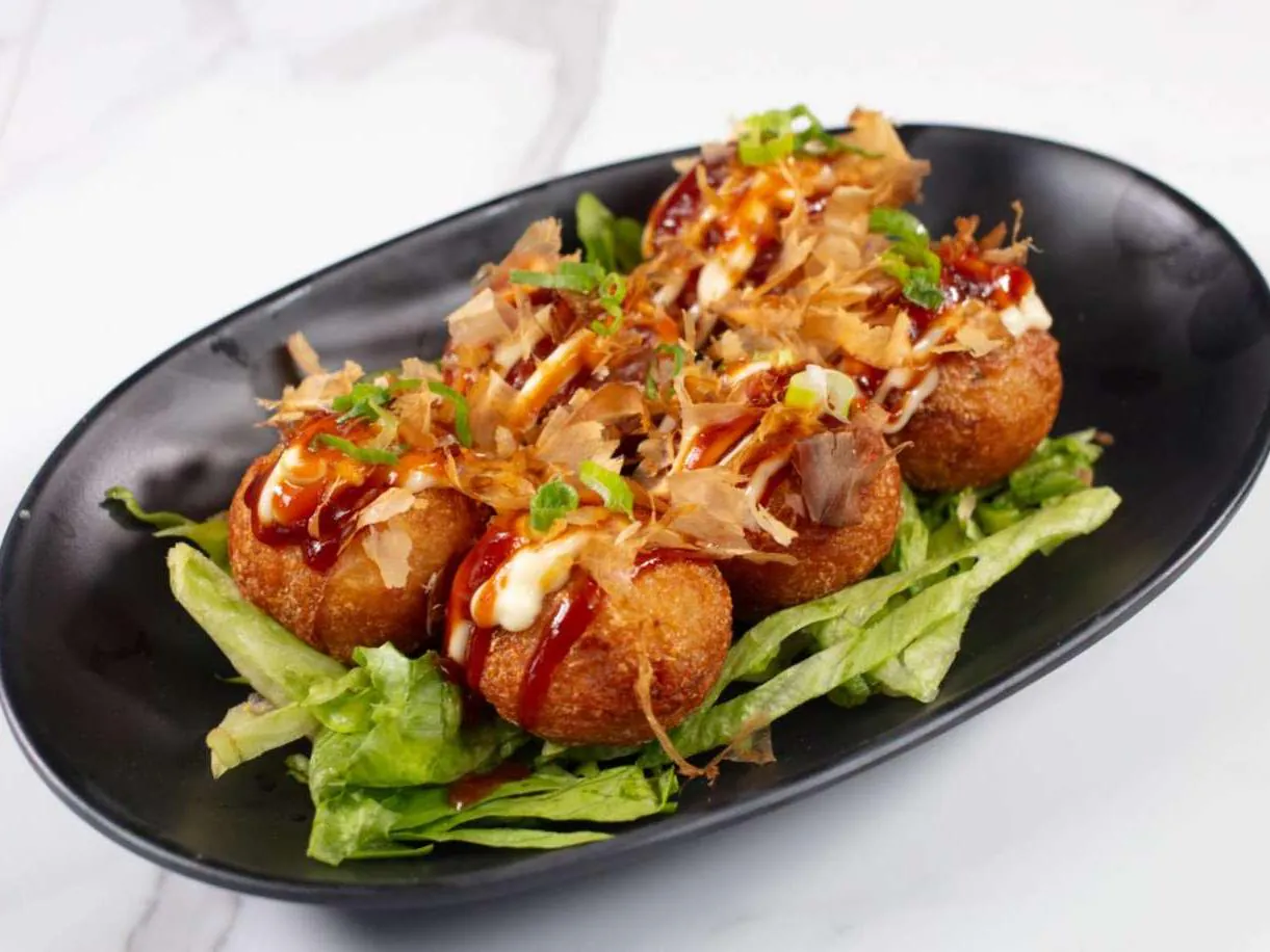 Savory octopus balls topped with sauce, mayo & bonito flakes at Taki Sushi, a Japanese Restaurant in Toronto