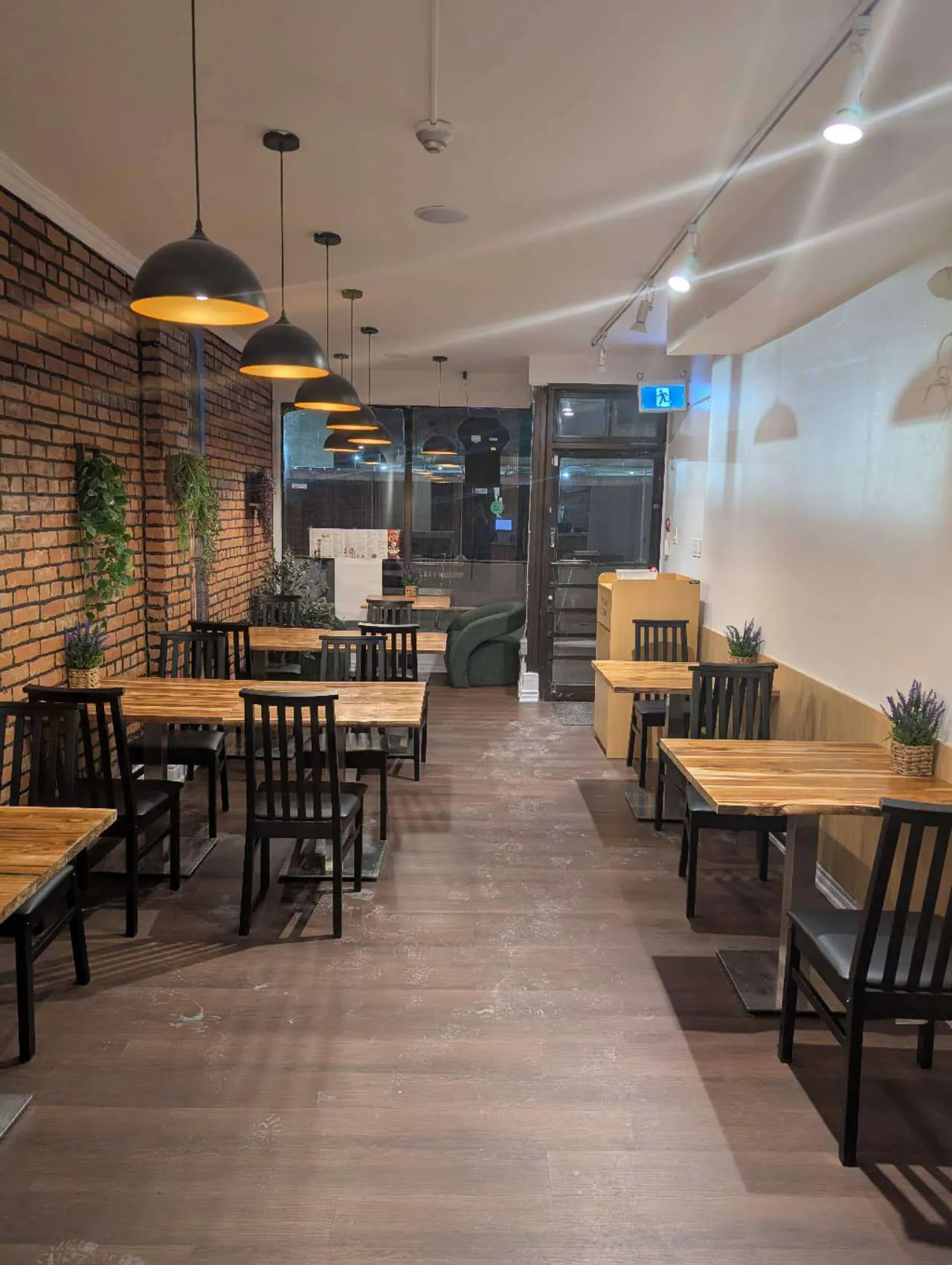 Taki-Sushi-Japanese-Restaurant-Dining-Area-Interior-Toronto Cozy dining space with brick wall, wooden tables & pendant lights at Taki Sushi, a Japanese Restaurant in Toronto